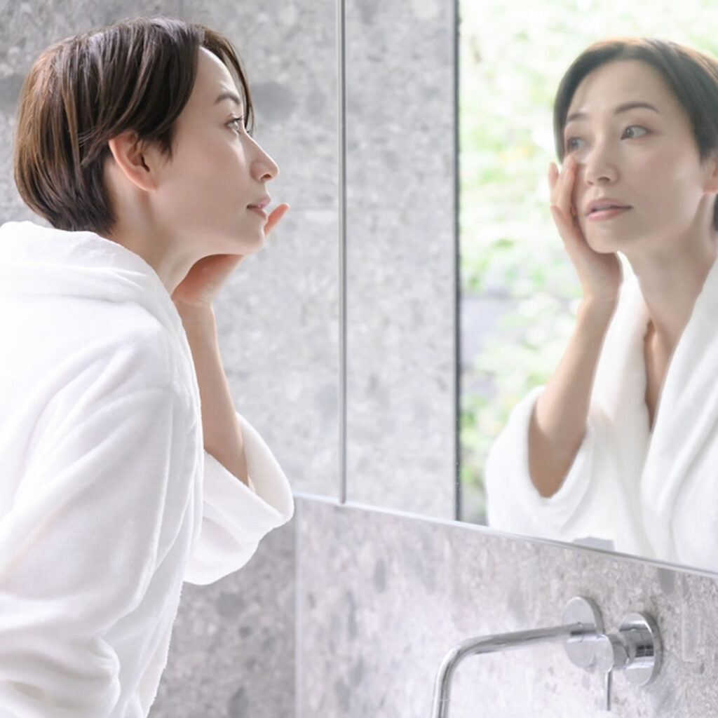 鏡を見てクマを気にしている女性