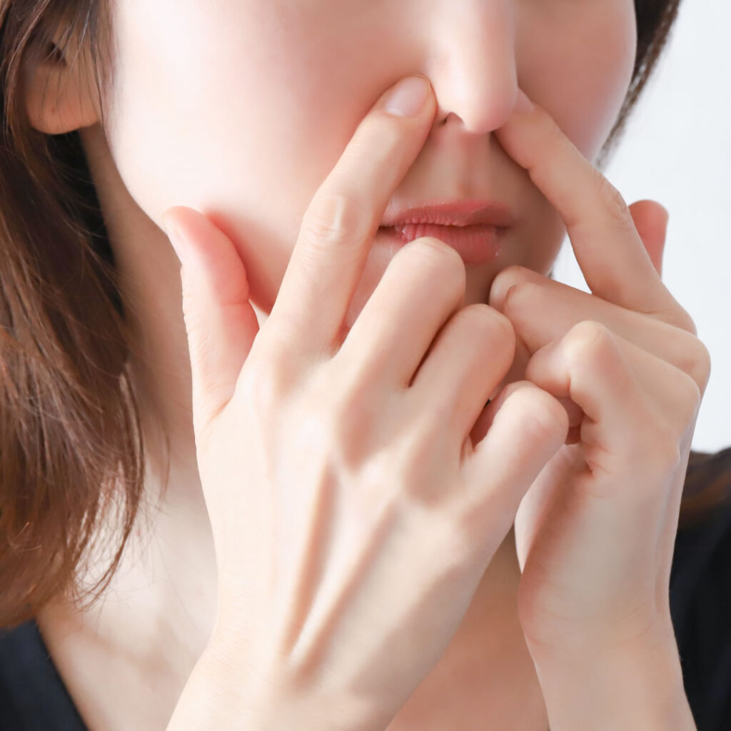 鼻を触る女性